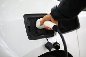 Driver inserts electric charger into vehicle